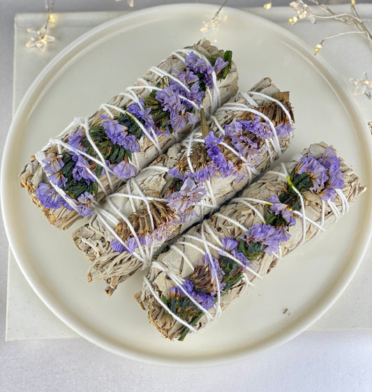 White sage smudge stick with purple flowers (Sea lavender).