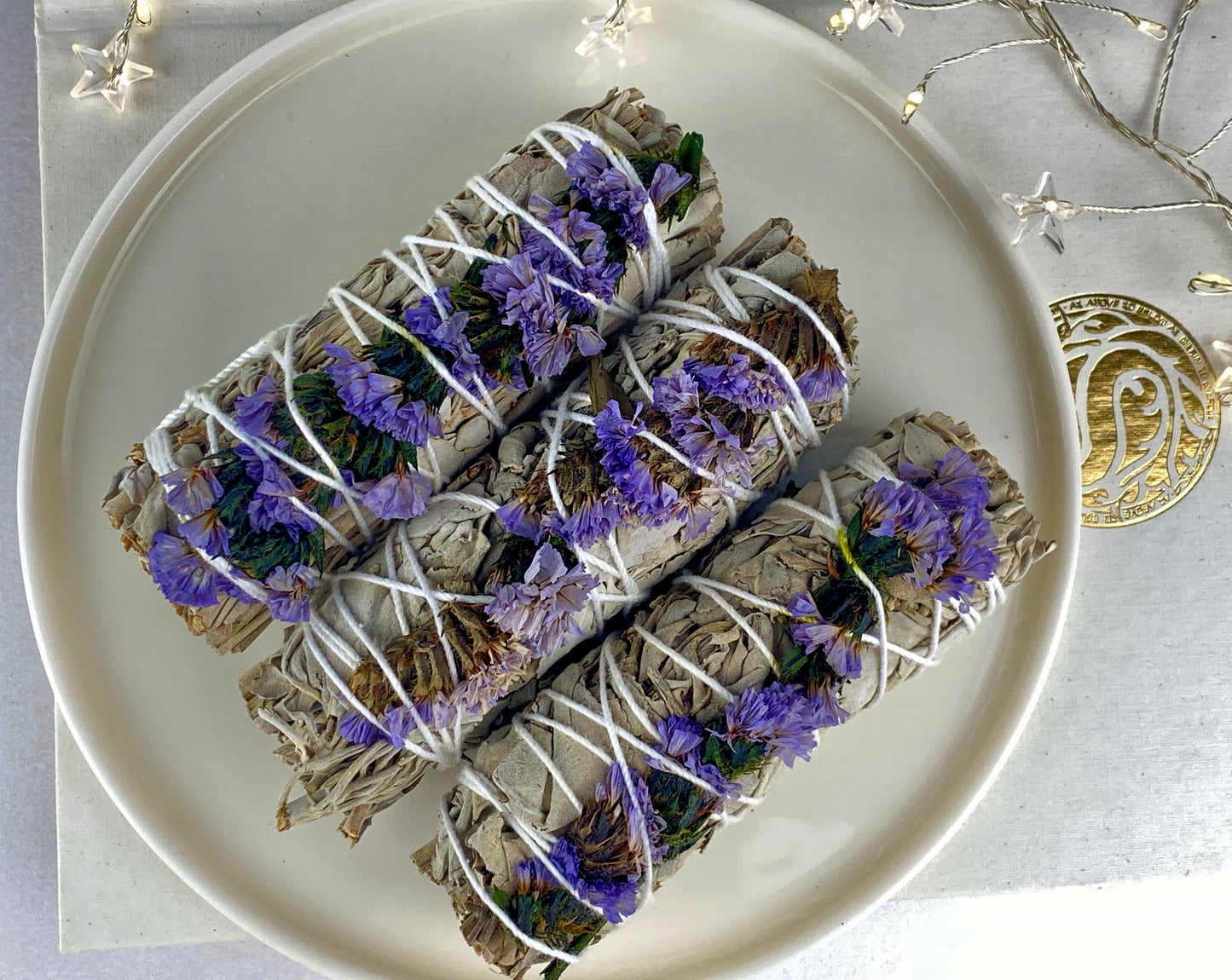 White sage smudge stick with purple flowers (Sea lavender).
